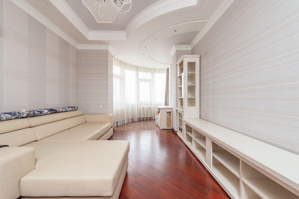 Sitting room with a smooth, freshly finished white ceiling and warm wood floor